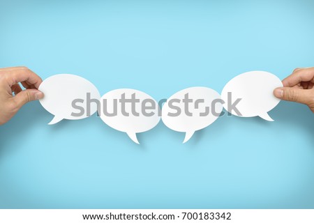 Two hands holding up four speech bubbles Royalty-Free Stock Photo #700183342
