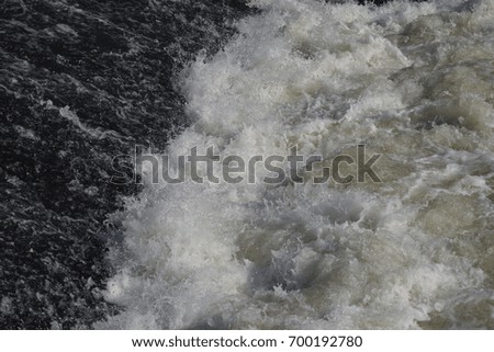Water surface with white foam and waves pattern