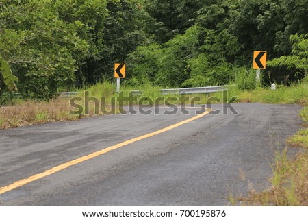 winding road sign, mountain background