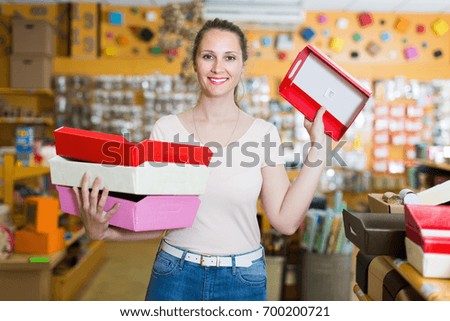 Young female with other multi colored gift boxes smiling at shop