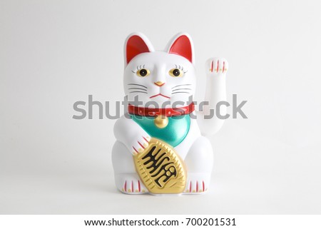 a Maneki-neko plastic cat, Symbolizing luck and wealth, on a white background Royalty-Free Stock Photo #700201531
