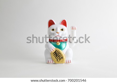 a Maneki-neko plastic cat, Symbolizing luck and wealth, on a white background Royalty-Free Stock Photo #700201546