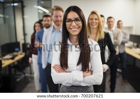 Business lady with positive look and cheerful smile posing for camera Royalty-Free Stock Photo #700207621