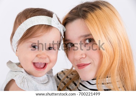 Two cousins on a white background. Infant and adult.