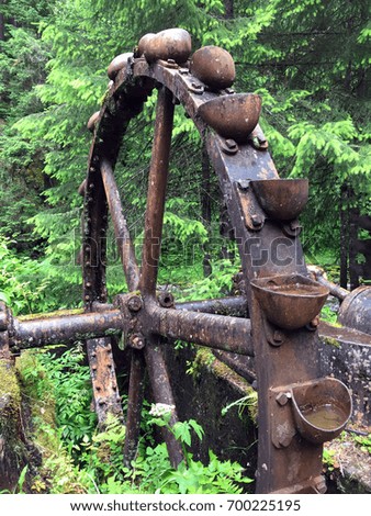 A large rusty water wheel for excavating minerals