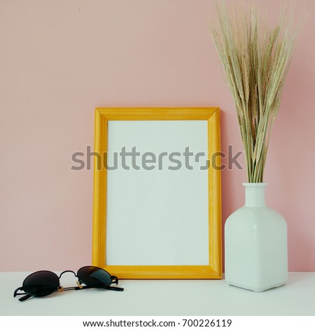 Wooden photo frame mockup, bouquet of barley spikelets in front of pale pink pastel background