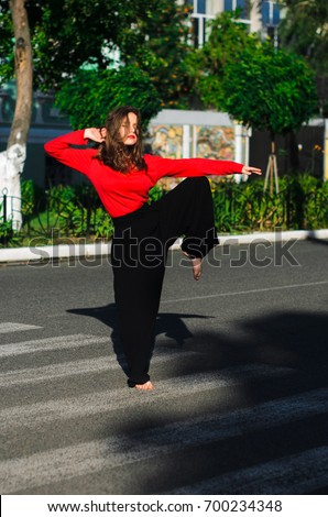 girls engaged in acrobatics and dancing on the street in the city