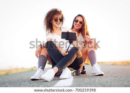 Skateboarder girl taking self portrait on smartphone