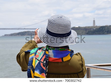 Photographing woman in colorful outdoor clothing at the Tagus
