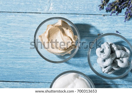 skin care and makeup product samples on blue wooden table background
