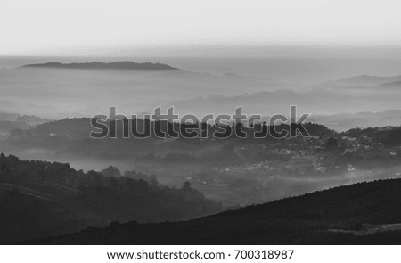 Black and white landscape with layers of foggy mountains