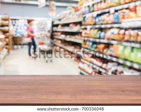 Brown wooden board empty table in front of blurred background. Perspective table over blur in supermarket - can be used for display or montage your products. Mockup for display of product.