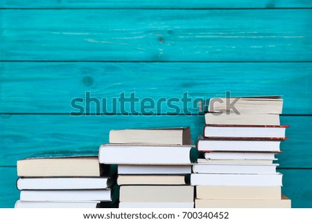 Stacks of books on wooden turquoise background. Free place for text. Education concept