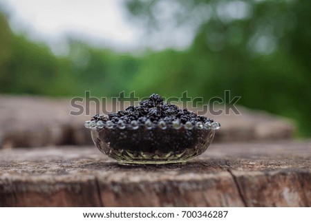 Berries in a vase on a wooden stump