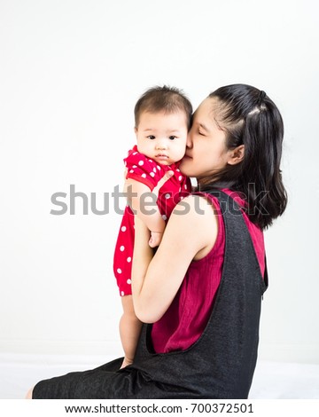 Portrait of happy asian mother kissing and hugging her cute little baby