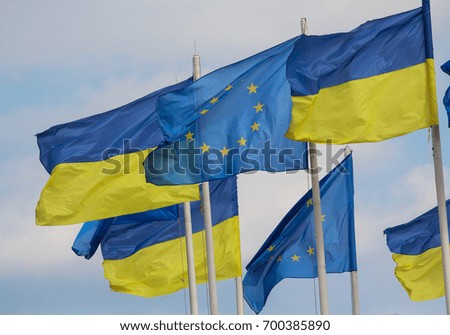 Flags of Ukraine and the European Union are developing against the background of the sky