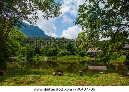Traditional wooden house near the lake and mountain in the background in the Kuching to Sarawak Culture village.Borneo, Malaysia