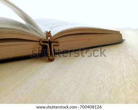 Christian Cross necklace with page opening Bible, selective focus with copy space