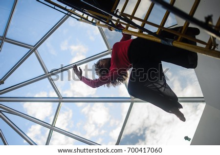 girl upside down with a happy smile on her face. on the background of the window. extreme