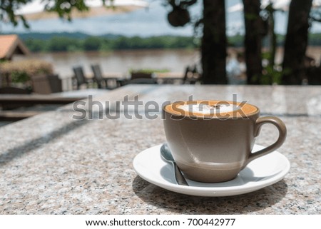 Cappuccino or Latte coffee art cup with heart shaped  on marble table  in cafe  Mekong Riverside at chiang khan, Loei Province, Thailand.