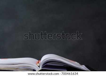 book and pencil on white table black board background with study and education concept.selective focus
