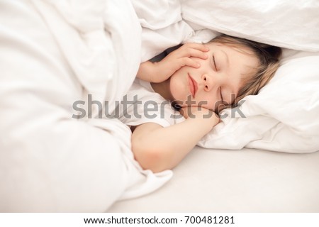 Child sleeping in bed Royalty-Free Stock Photo #700481281