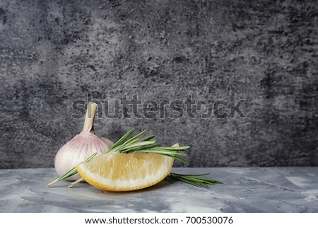 Fresh rosemary, lemon and garlic on table