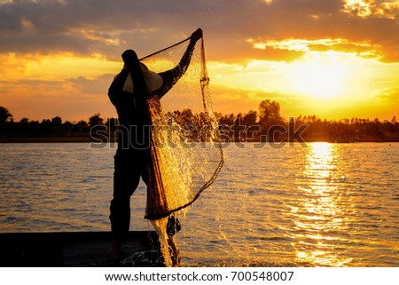 fisherman in action during sunset at golden time