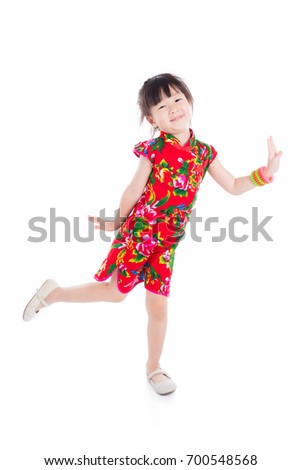 Full length of little asian girl wearing red chinese traditional dress standing and smiles over white background
