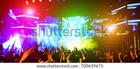 Blurred people dancing and having fun in summer festival party outdoor - Crowd with hands up celebrating fest concert event - Defocused image - Blurry photo