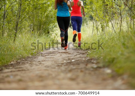 Two running athletes in park