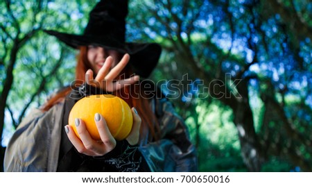 Photo of witch with pumpkin reading spells