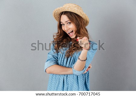 Image of happy young caucasian lady pointing at you. Looking camera.