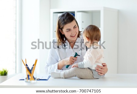 medicine, healthcare, pediatry and people concept - otolaryngologist or doctor with baby and otoscope at clinic