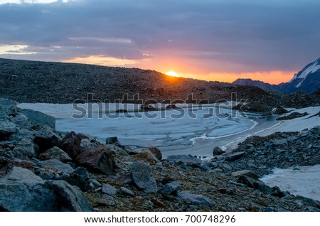 Caucasian mountains and the lake near the Songuti glacier. Beautiful morning sunrise.