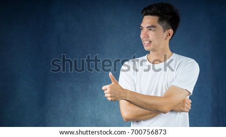Portrait handsome young asian man wearing a white shirt thump up isolated on dark background. Asia man people. business concept.Copy space.
