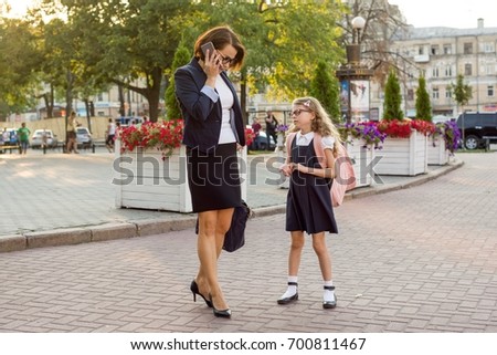 Mother businesswoman takes the child to school.