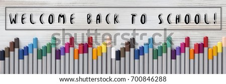 Welcome back to school Large background or banner. Multicolored pencils lie on a light wooden table. Beautiful tools for drawing. Knowledge Day design concept. Beautiful tools for drawing.Flat Lay.