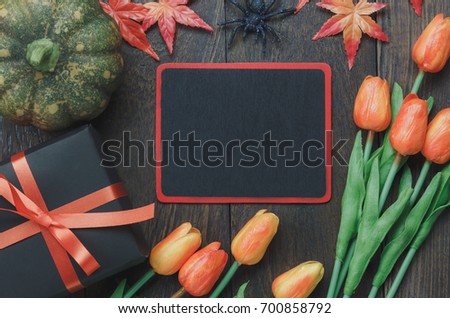 Table top of decoration sign Happy Halloween festival background. with beautiful orange tulip and maple leaf.Mix object on rustic modern wooden desk.Copy space for text information.Dark tone design.