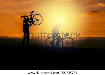 Two biker relaxing on the sunset background.