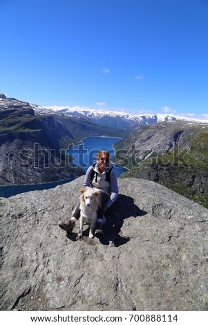 Hiker with dog on the Trolltunga