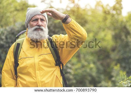 Thoughtful senior male traveler looking at natural scene