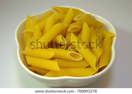 A bowl of raw pasta penne. 