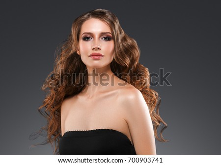 Woman with red lipstick. Curly Hair. Fashion Girl With Healthy Long Wavy Hair. Beauty Brunette Woman Portrait.Hair Extension, Permed Hair over dark background