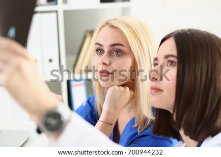 Group of beautiful female doctors hold in hand and look at xray photography to detect problem. Bone disease exam, medic assistance, cancer aid, healthy lifestyle, ill test, hospital practice concept