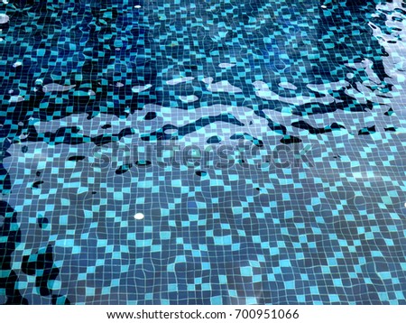 Swimming pool with vivid blue distorted tile pattern.