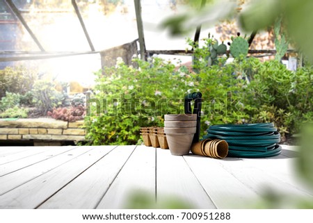 Autumn beautiful garden with white wooden table and garden tools