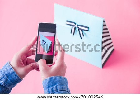young women taking photo to bags with cell telephone or smartphone digital camera for Post to sell Online on the Internet . Customise pastel bright colors tone .