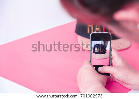 young women taking photo to hat with cell telephone or smartphone digital camera for Post to sell Online on the Internet . Customise pastel bright colors tone .