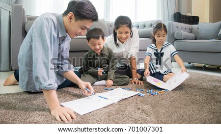 Father and mother Teaching children to do their homework at home ,and relax with they son to do home work by draw and paint, family , kid , education concept.